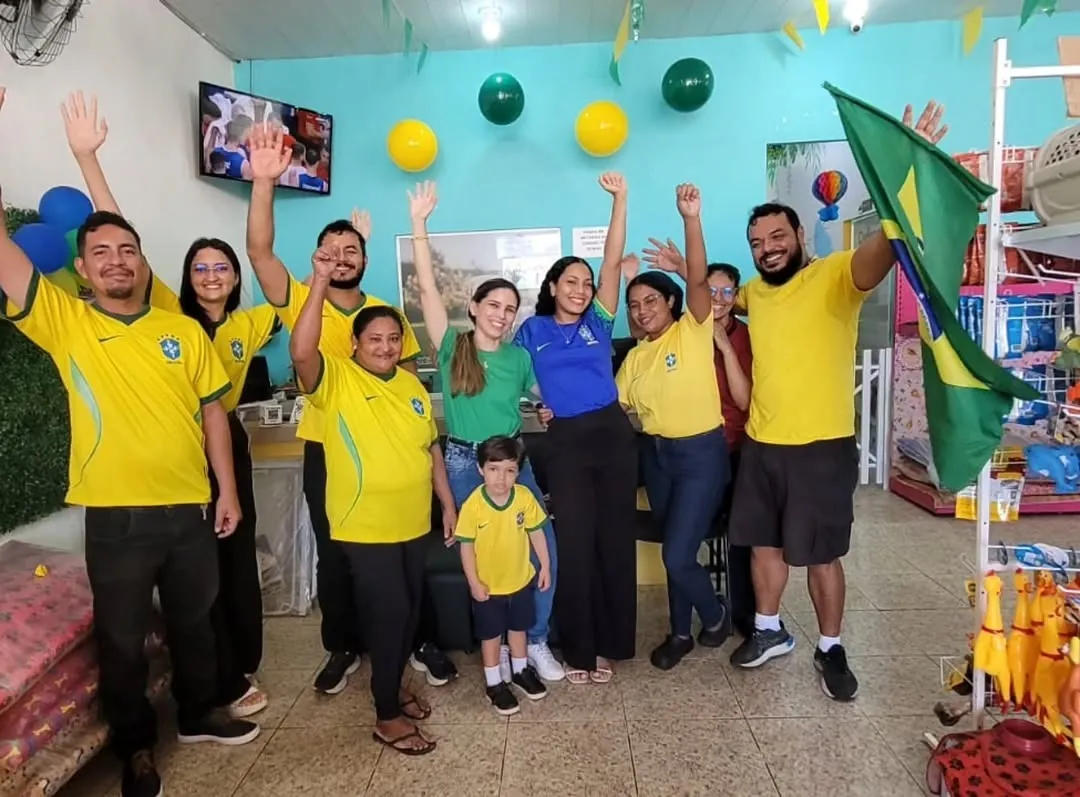 Equipe da Pet Natureza com camisas do Brasil comemorando na loja